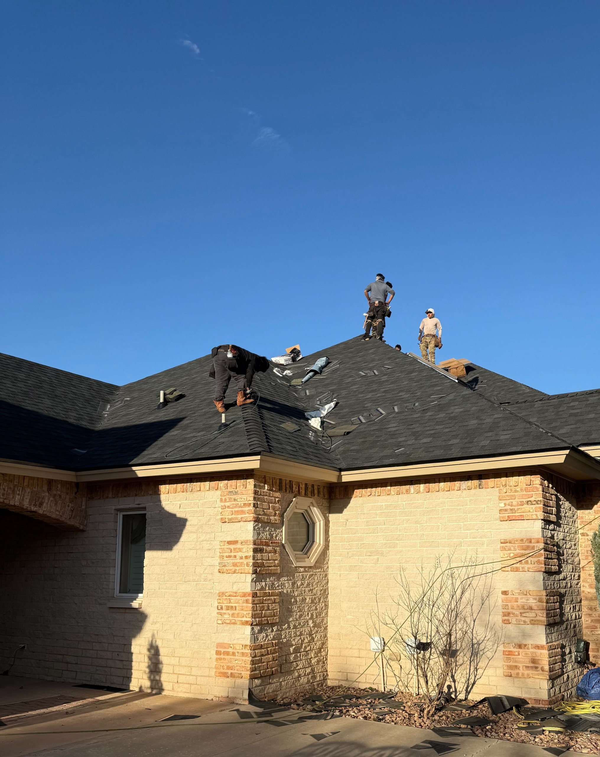 Experienced roofer inspecting flashing and decking during complete roof replacement