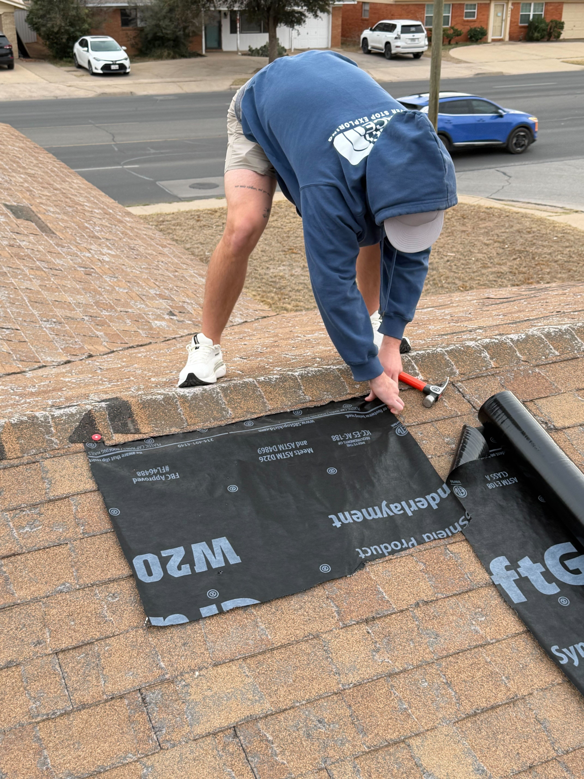 Experienced roofer documenting hail impact and flashing damage for detailed insurance review