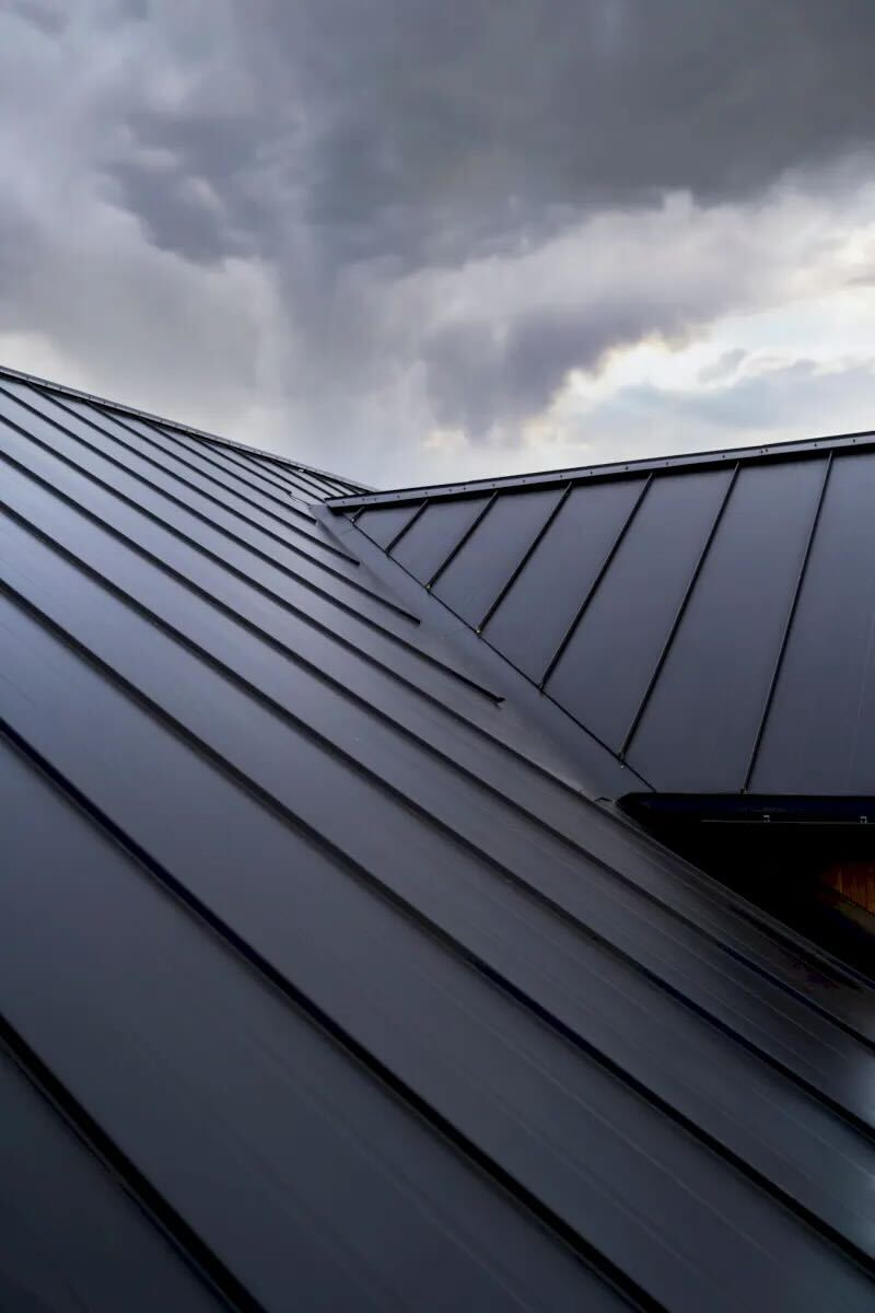 Homeowner reviewing storm damage photos with roofer during insurance claim consultation